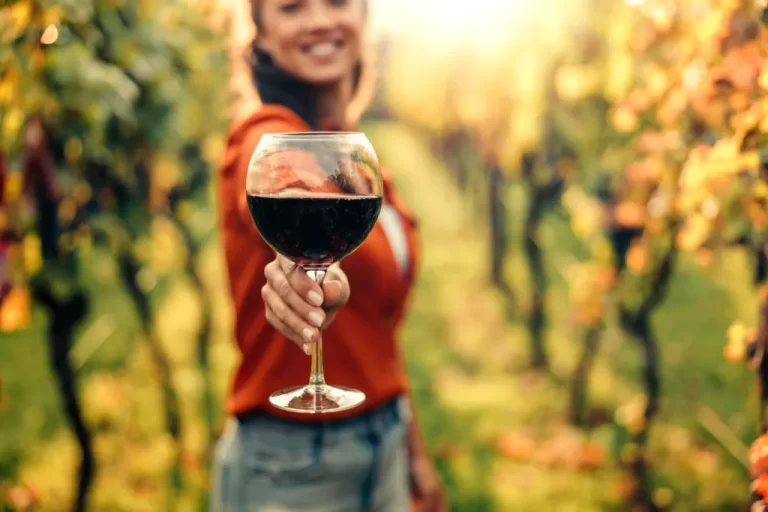 bodega de vinos mujer con copa de vino en mano en el atardecer